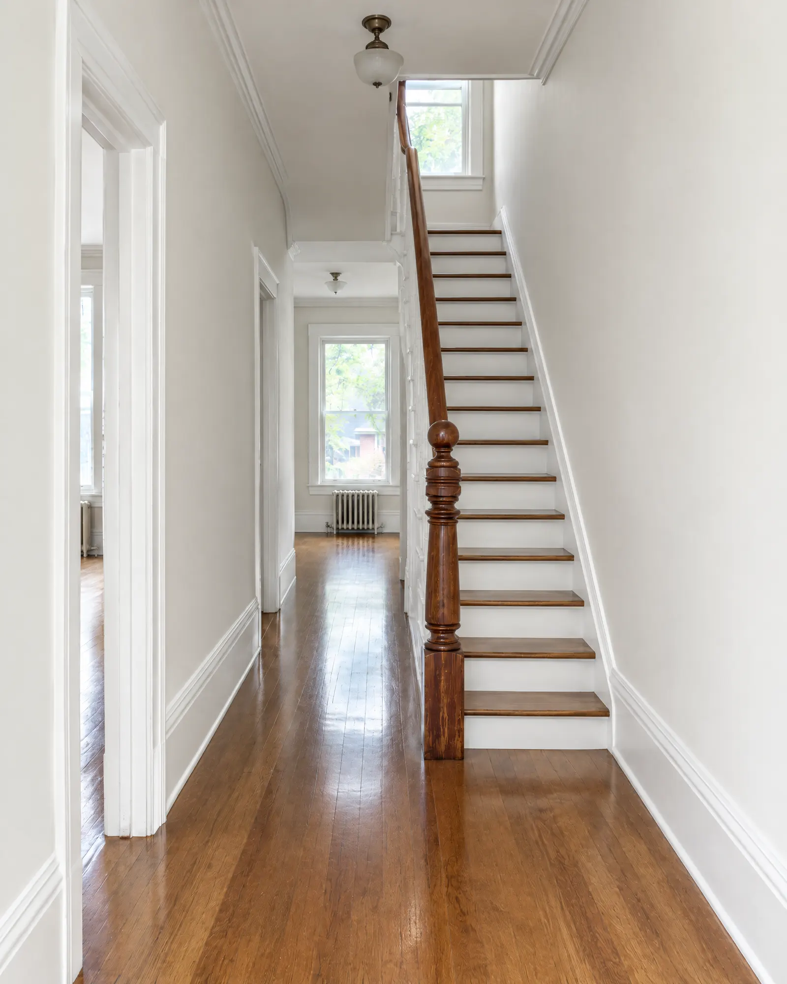 The same hallway after painting: smooth warm-white walls, crisp white trim