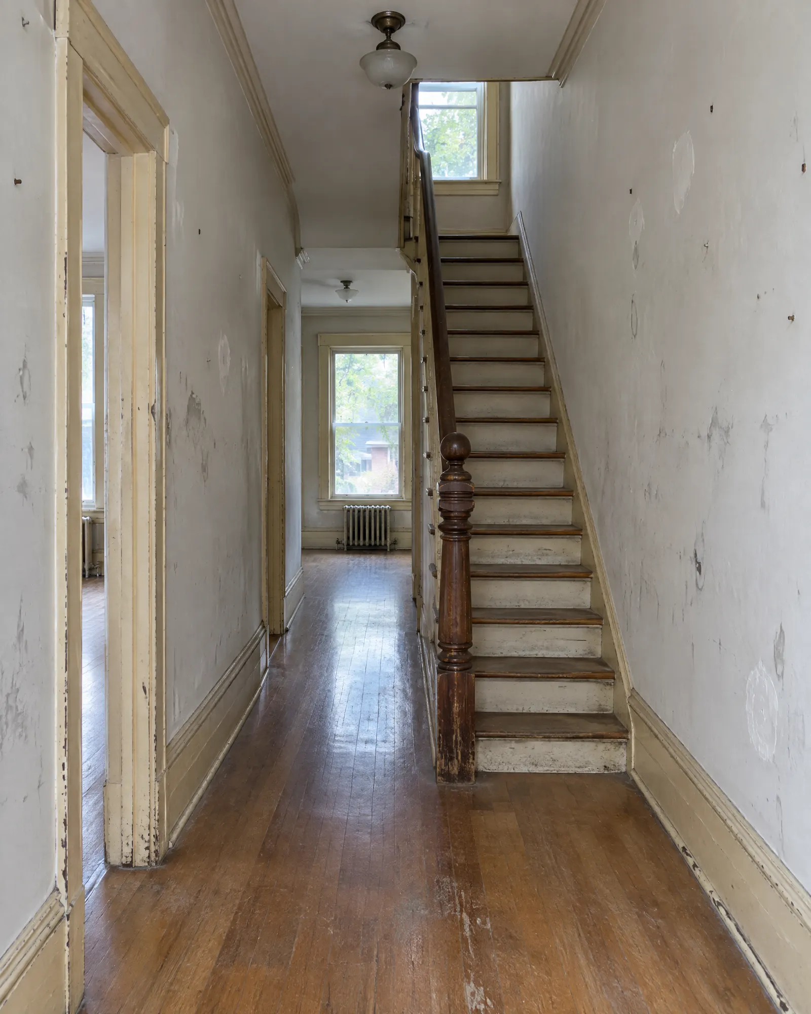 Hallway in an older Toronto house before painting: scuffed walls, yellowed trim